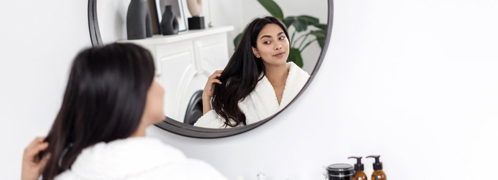 Woman with hair mask relaxing at home, emphasizing the ease of DIY hair spa and its benefits for hair health.