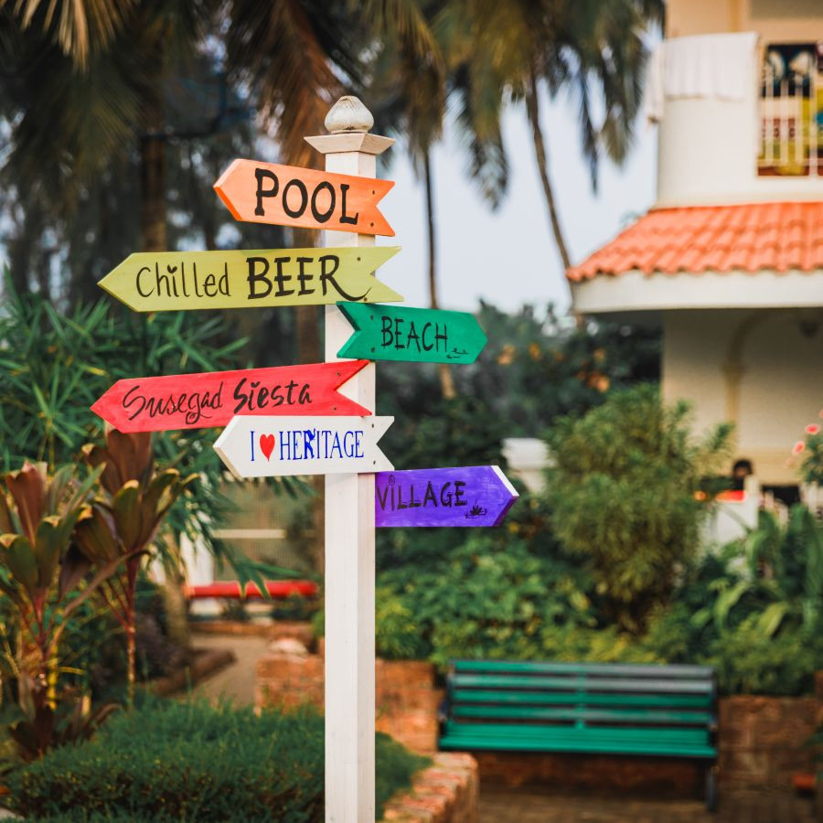 Chic signage for weddings at Heritage Village Resorts &amp; Spa Goa, indicating pool, chilled beer, and beachside celebration.