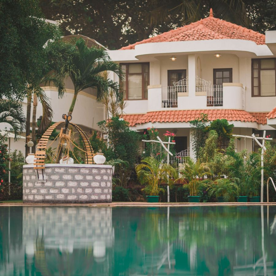 Poolside exterior of Heritage Village Resorts &amp; Spa, Goa, showcasing the beautiful resort ambiance.