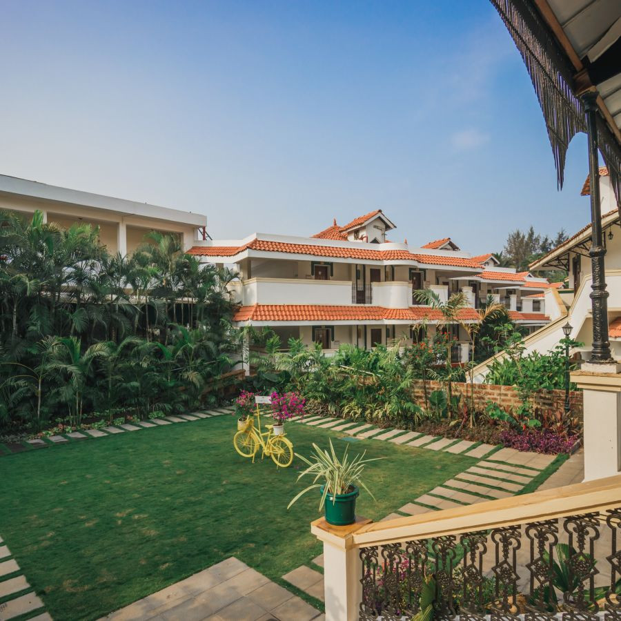 Verdant lawns of Heritage Village Resorts &amp; Spa, Goa, presenting the lush greenery and tranquil environment.