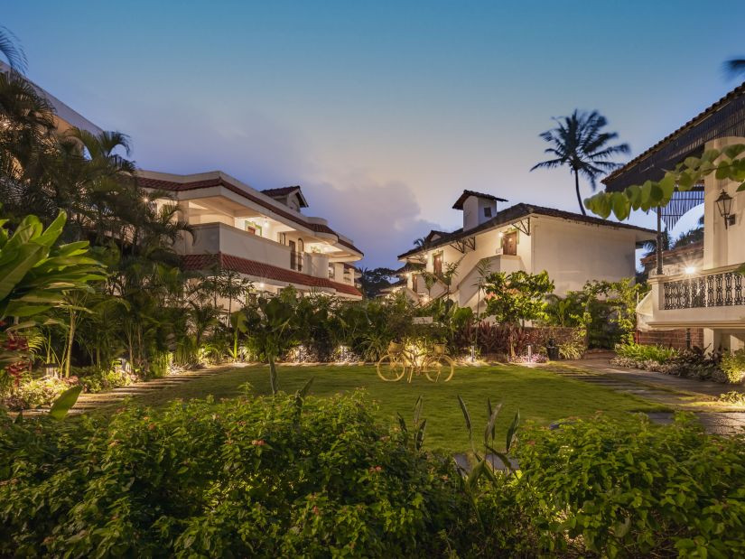 Exterior view of Heritage Village Resorts & Spa, Goa, showcasing its Portuguese-style architecture and lush greenery.