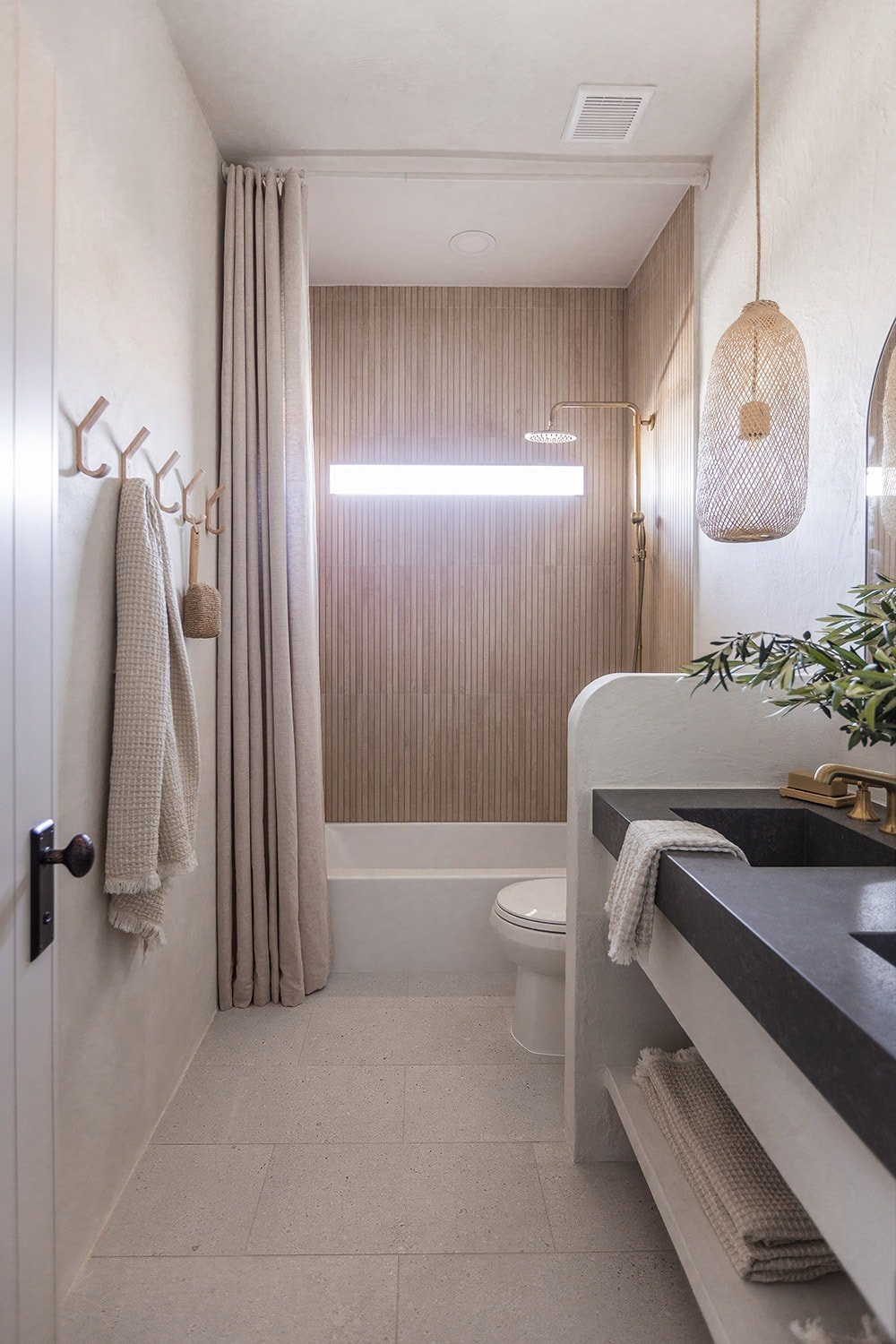 Modern minimalist bathroom with microcement walls, custom vanity, and quartz countertop with integrated double sinks.