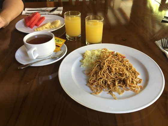 Buffet selection of Asian and Western breakfast items including rice, noodles, potatoes, sausages, bacon, Indonesian dish, and baked beans at Astagina Resort Villa and Spa