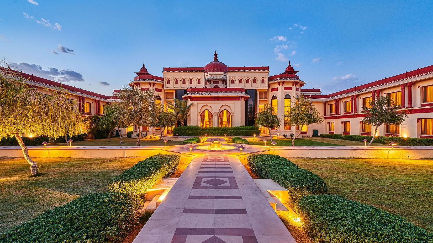 Serene courtyard view at The Ummed Jodhpur Palace Resort & Spa, showcasing traditional Rajasthani architecture and lush greenery.