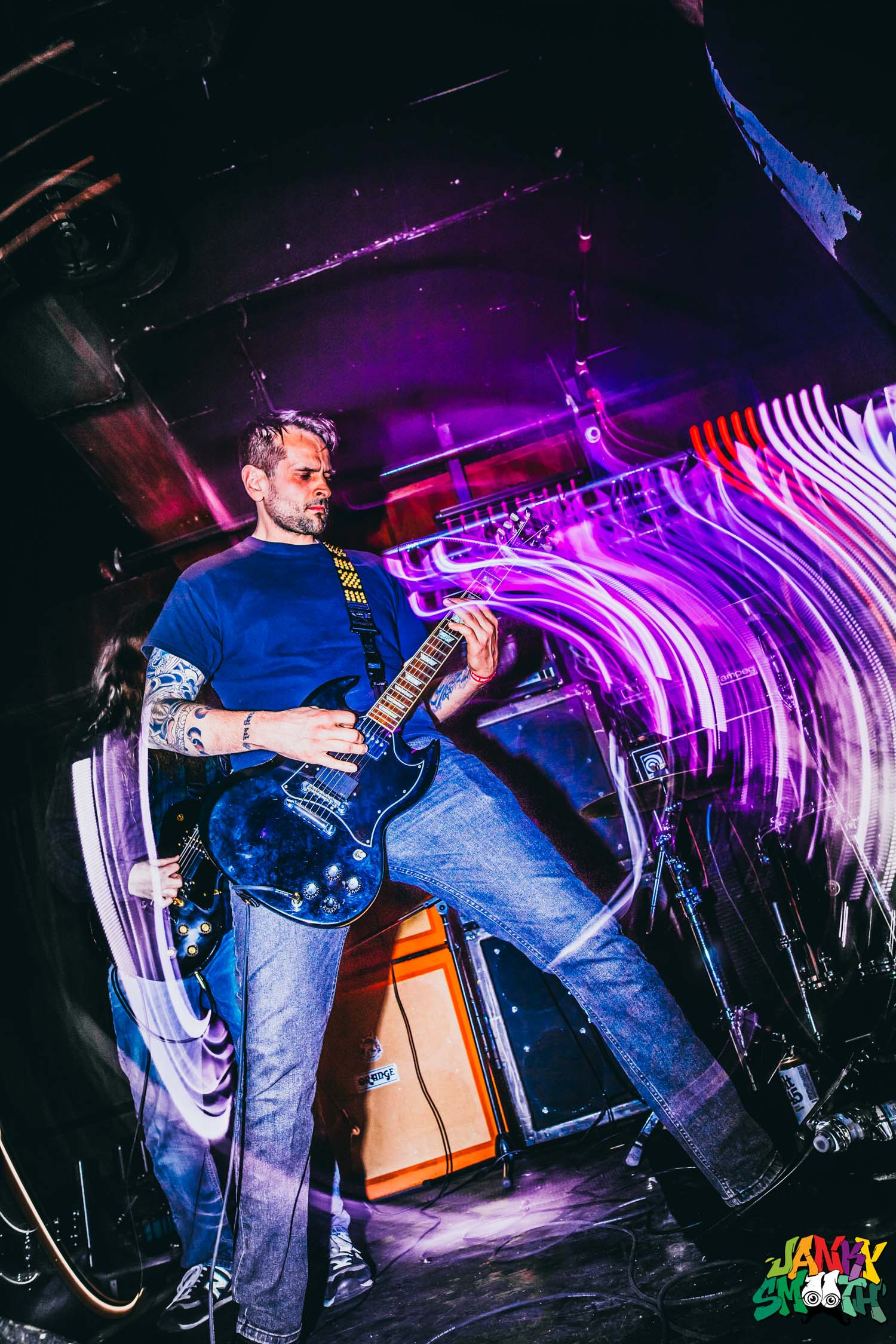 Ilsa performing live at Los Globos, bathed in red stage lighting, showcasing the raw energy of their doom metal set.