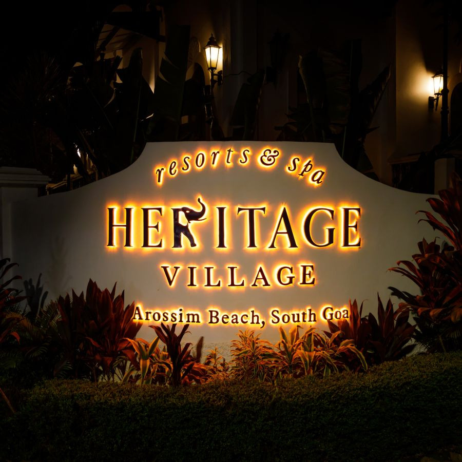 Entrance signage of Heritage Village Resorts &amp; Spa in Goa, welcoming guests to the luxury destination.