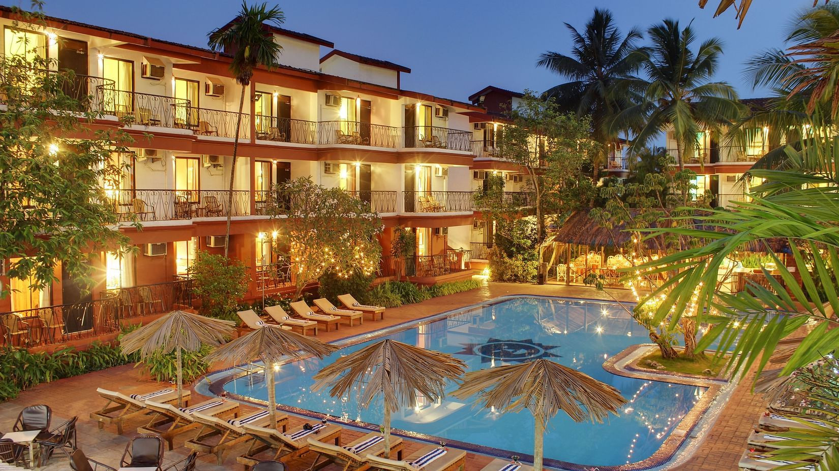 Swimming pool with clear blue water and lounge chairs, showcasing the resort's relaxing ambiance.