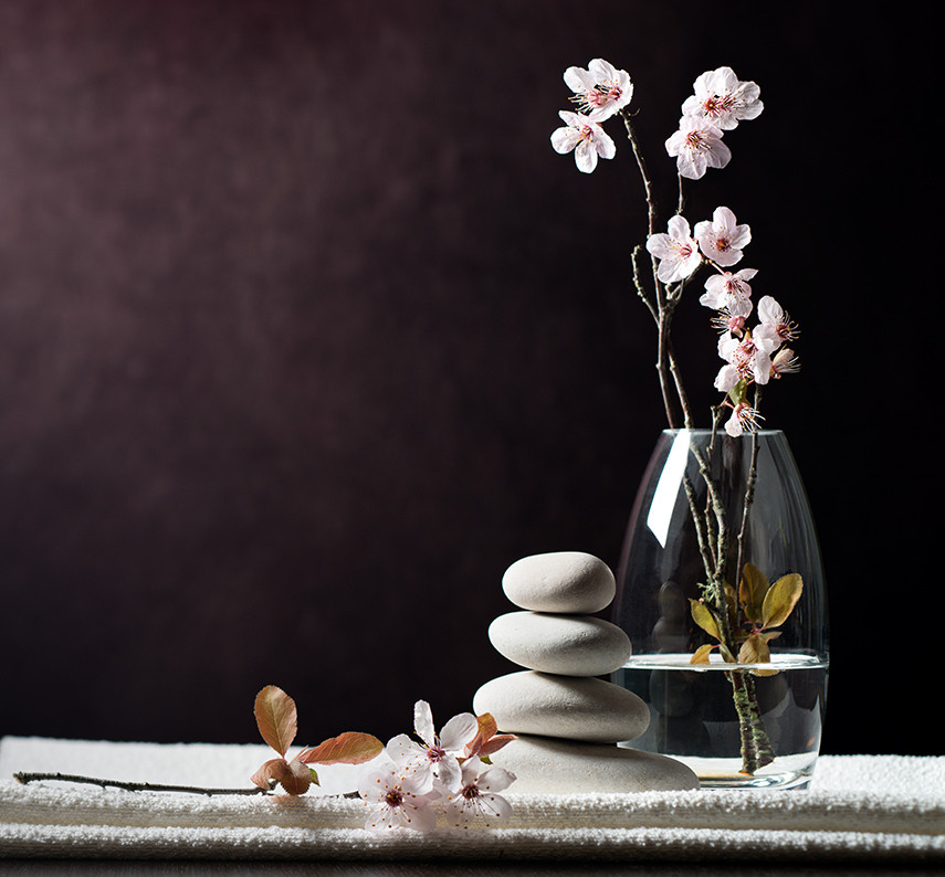 a vase with flowers in it and a stack of rocks
