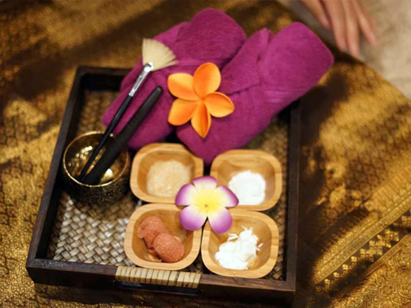 Woman in a white spa robe enjoying a cup of tea at a spa
