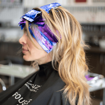 Hair stylist working on a client's hair at Foushee Salon