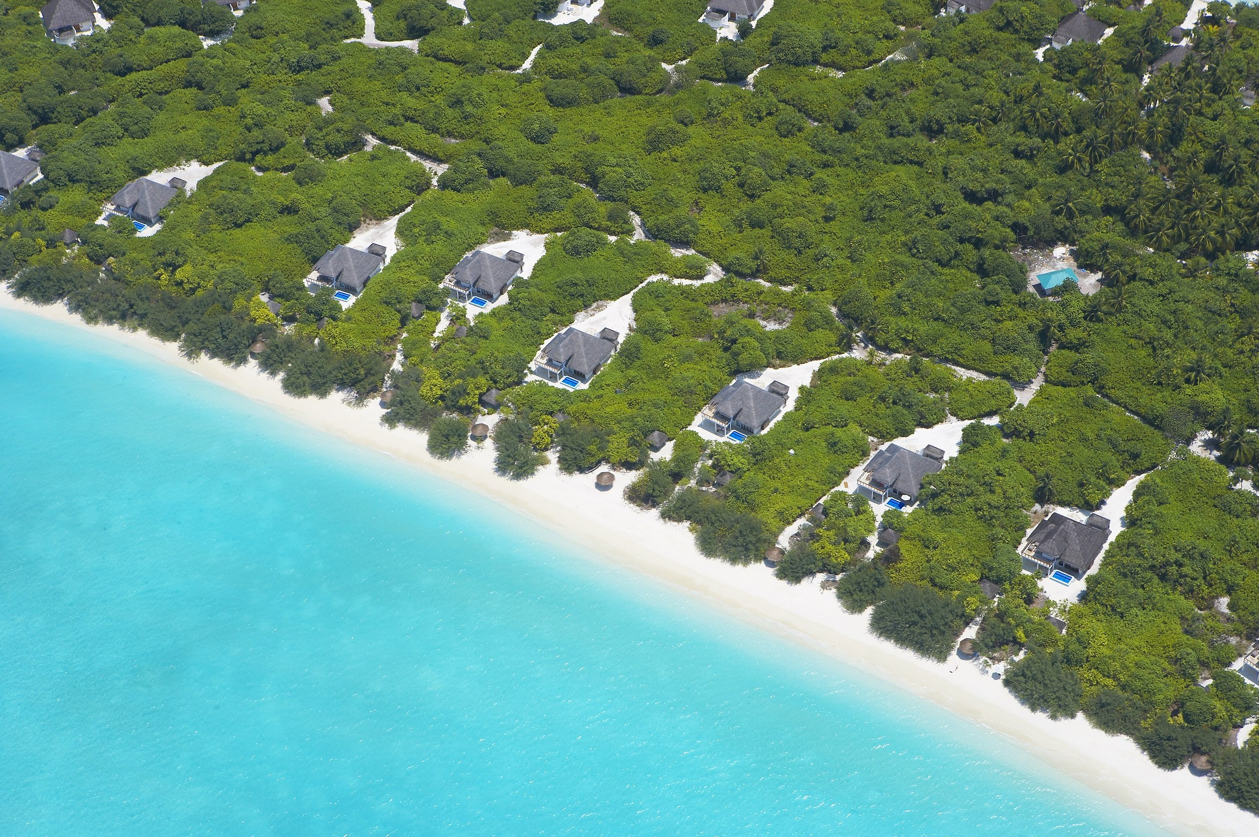 An aerial view of Hideaway Beach Resort & Spa Maldives, showcasing its secluded location and the pristine waters surrounding it.
